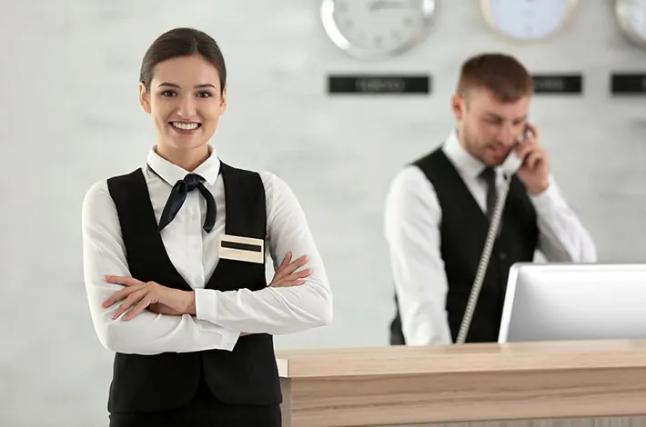 Recepcionistas uniformizados no balcão de atendimento